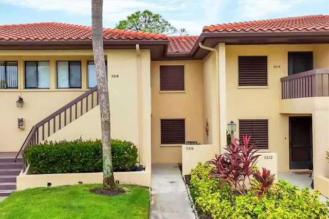 a view of a house with potted plants and a table and plants