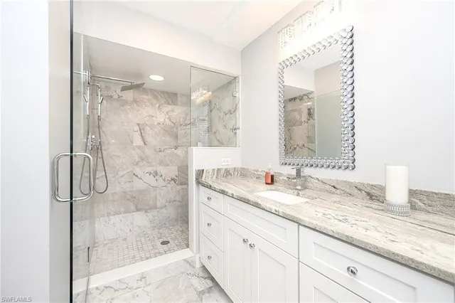 a bathroom with a granite countertop sink mirror and shower