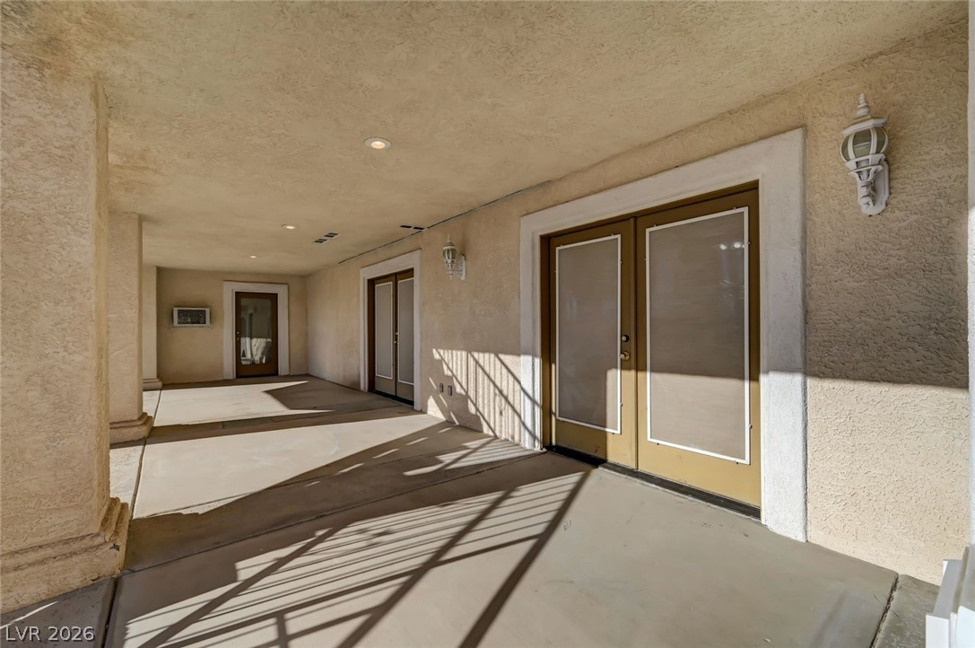640 North Racetrack Road Henderson, NV 89015 - Photo 40 of 65 A graceful outdoor walkway with sturdy columns and bright recessed lighting leads to private entrances.