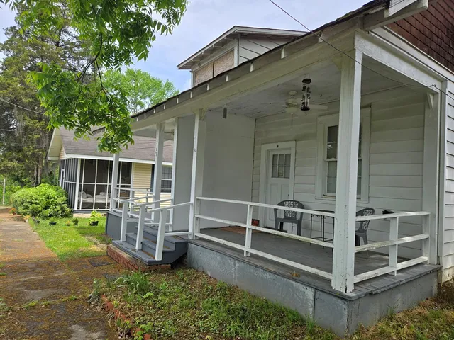 a view of house with backyard and porch