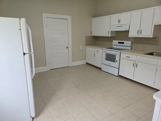 a kitchen with cabinets and white stainless steel appliances