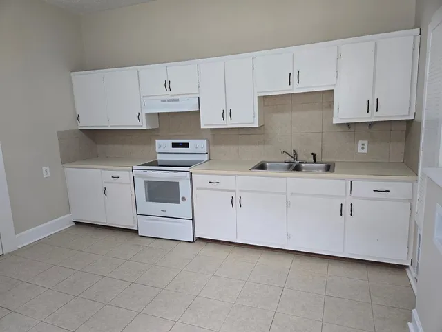 a kitchen with cabinets appliances a sink and a counter top