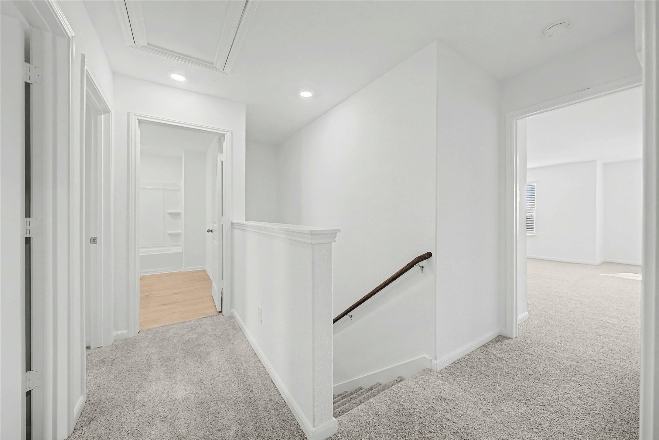 237 Fairlawn Way Maxwell, TX 78656 - Photo 11 of 12 Well-lit hallway featuring light grey carpet, white walls, and a staircase with a wooden handrail