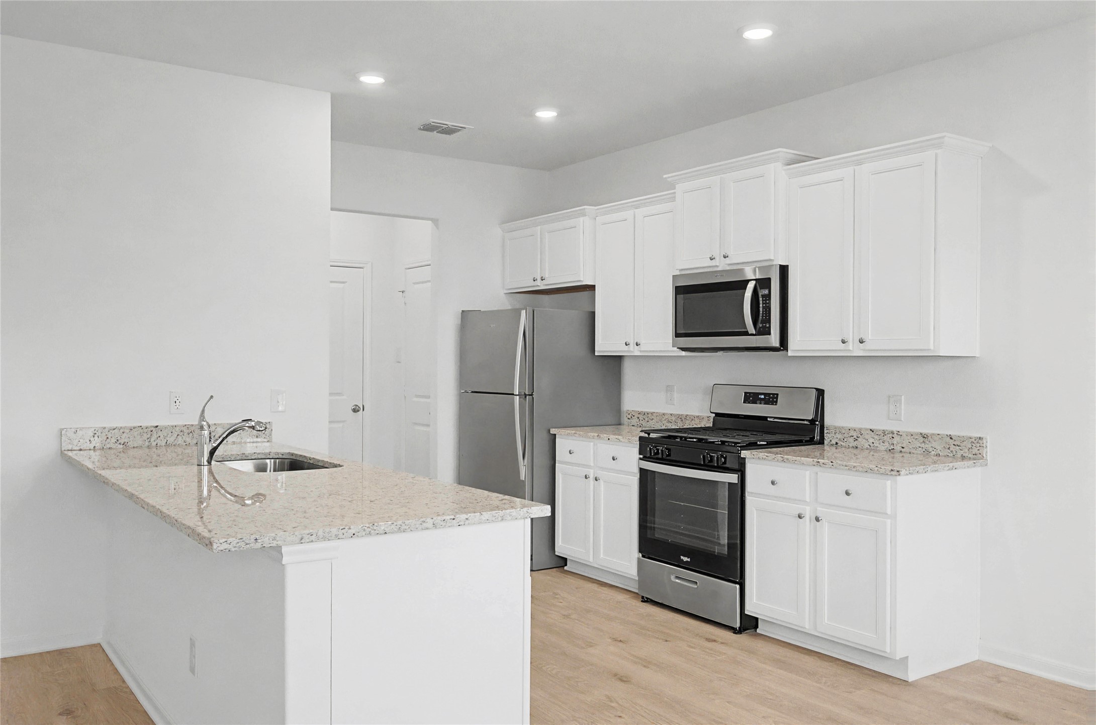 237 Fairlawn Way Maxwell, TX 78656 - Photo 3 of 12 Kitchen featuring white cabinetry, granite countertops, stainless steel appliances, and light-colored flooring