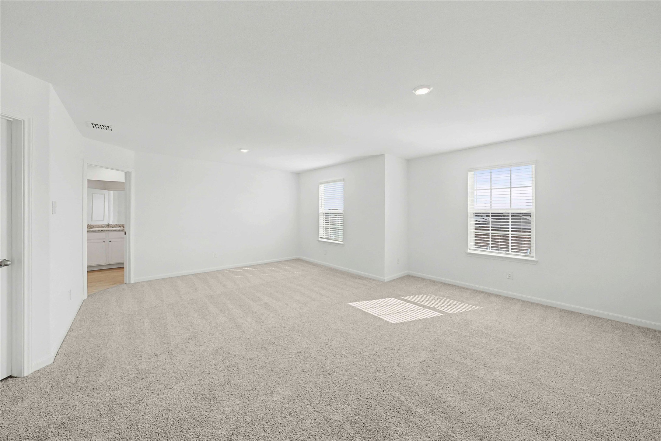 237 Fairlawn Way Maxwell, TX 78656 - Photo 6 of 12 Spacious room featuring light-colored carpet, white walls, recessed lighting, and two windows with blinds