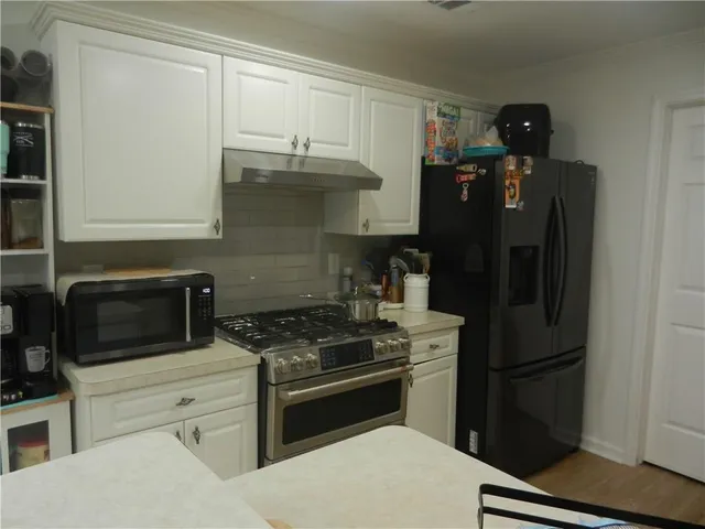 a kitchen with stainless steel appliances granite countertop a refrigerator stove and microwave