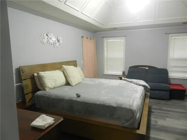 a bedroom with a bed and wooden floor