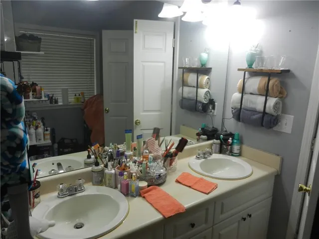 a bathroom with double vanity sink and a mirror