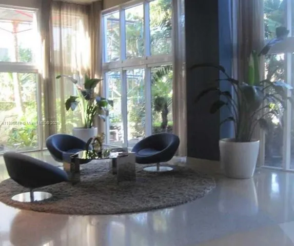 a living room with furniture a window and a potted plant