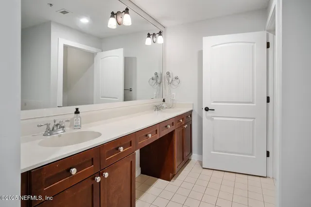 a spacious bathroom with a double vanity sink a mirror and a shower