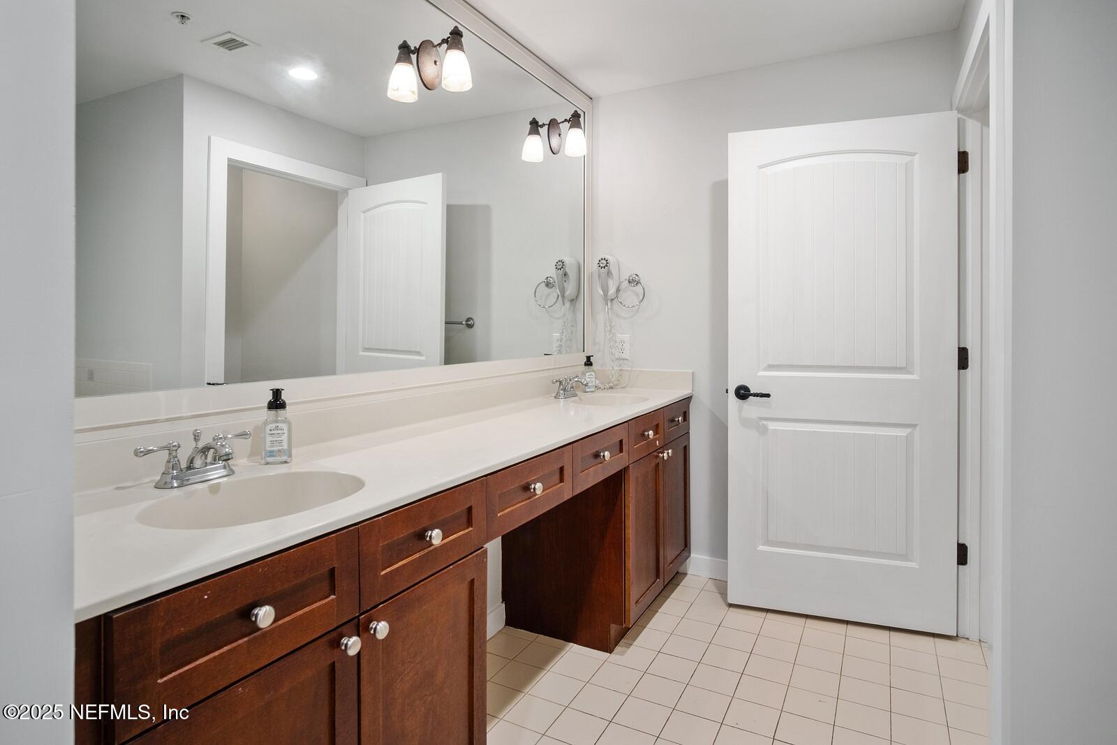 945 Registry Boulevard, Unit 210 St. Augustine, FL 32092 - Photo 15 of 28 a spacious bathroom with a double vanity sink a mirror and a shower