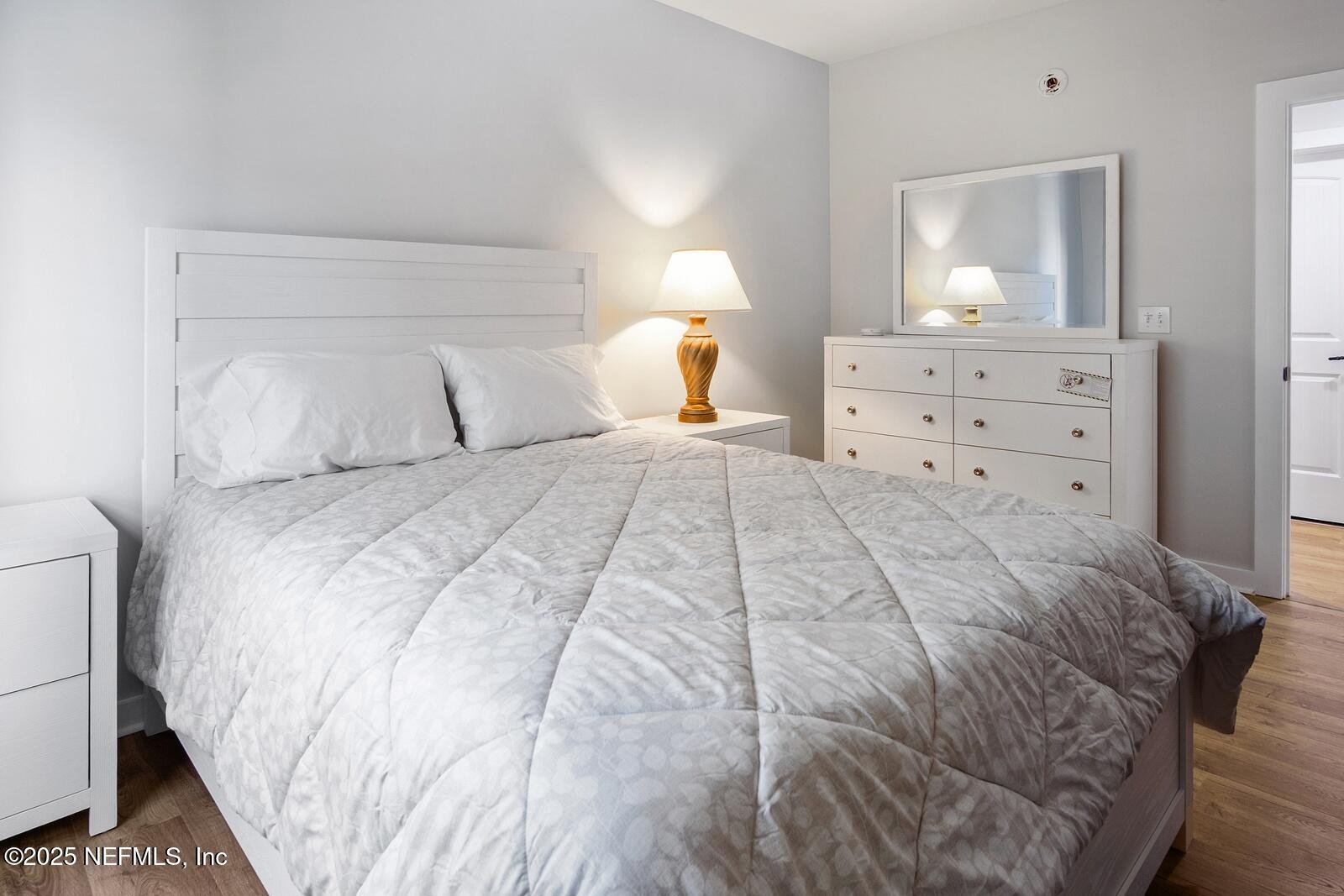 945 Registry Boulevard, Unit 210 St. Augustine, FL 32092 - Photo 18 of 28 a bedroom with a bed and a night stand