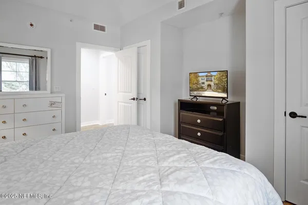 a bedroom with a bed and a television