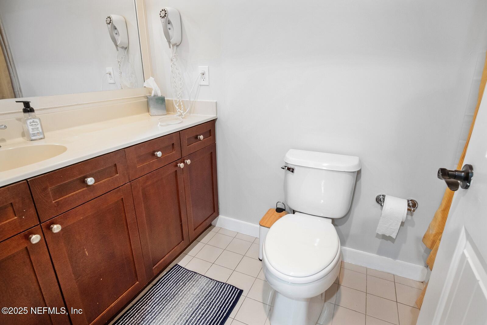 945 Registry Boulevard, Unit 210 St. Augustine, FL 32092 - Photo 20 of 28 a bathroom with a toilet sink and mirror