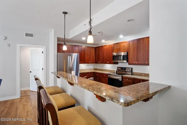 a kitchen with stainless steel appliances granite countertop a sink refrigerator and cabinets