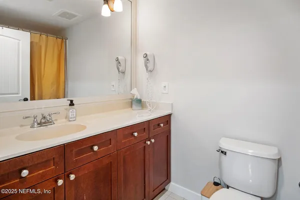 a bathroom with a double vanity sink toilet and a mirror