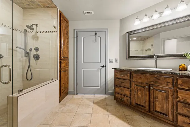 a bathroom with a shower sink and mirror