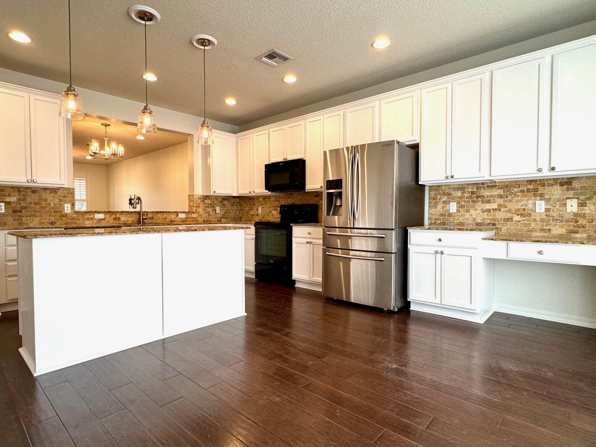 1346 Turnbridge Drive Jupiter, FL 33458 - Photo 12 of 46 a kitchen with stainless steel appliances granite countertop a refrigerator a sink a stove and oven