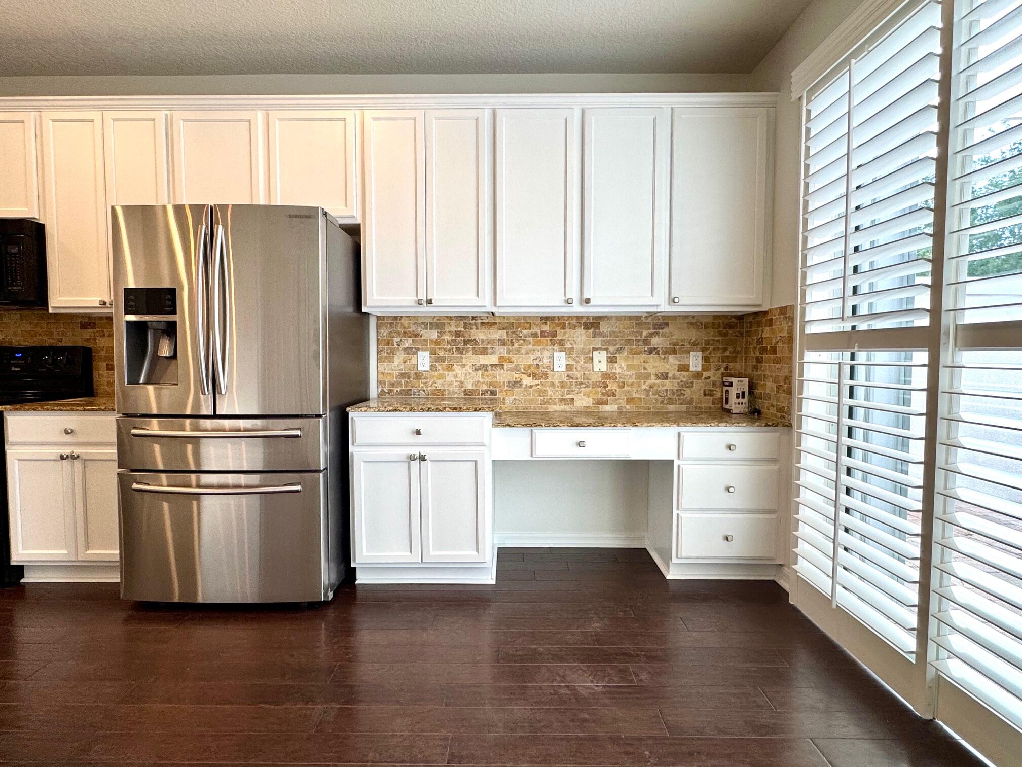 1346 Turnbridge Drive Jupiter, FL 33458 - Photo 13 of 46 a kitchen with granite countertop white cabinets and stainless steel appliances