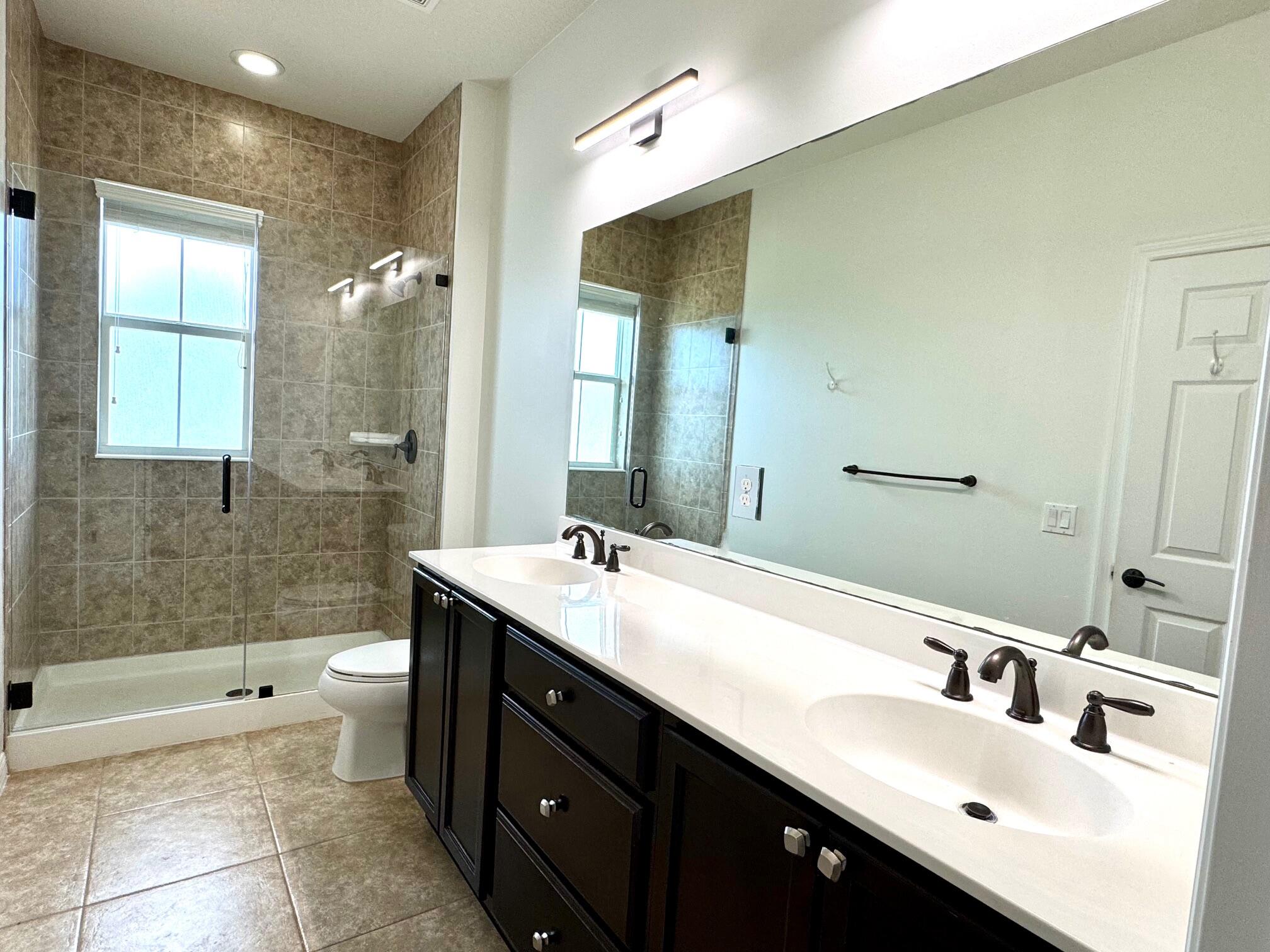 1346 Turnbridge Drive Jupiter, FL 33458 - Photo 14 of 46 a bathroom with a double vanity sink toilet and a tub