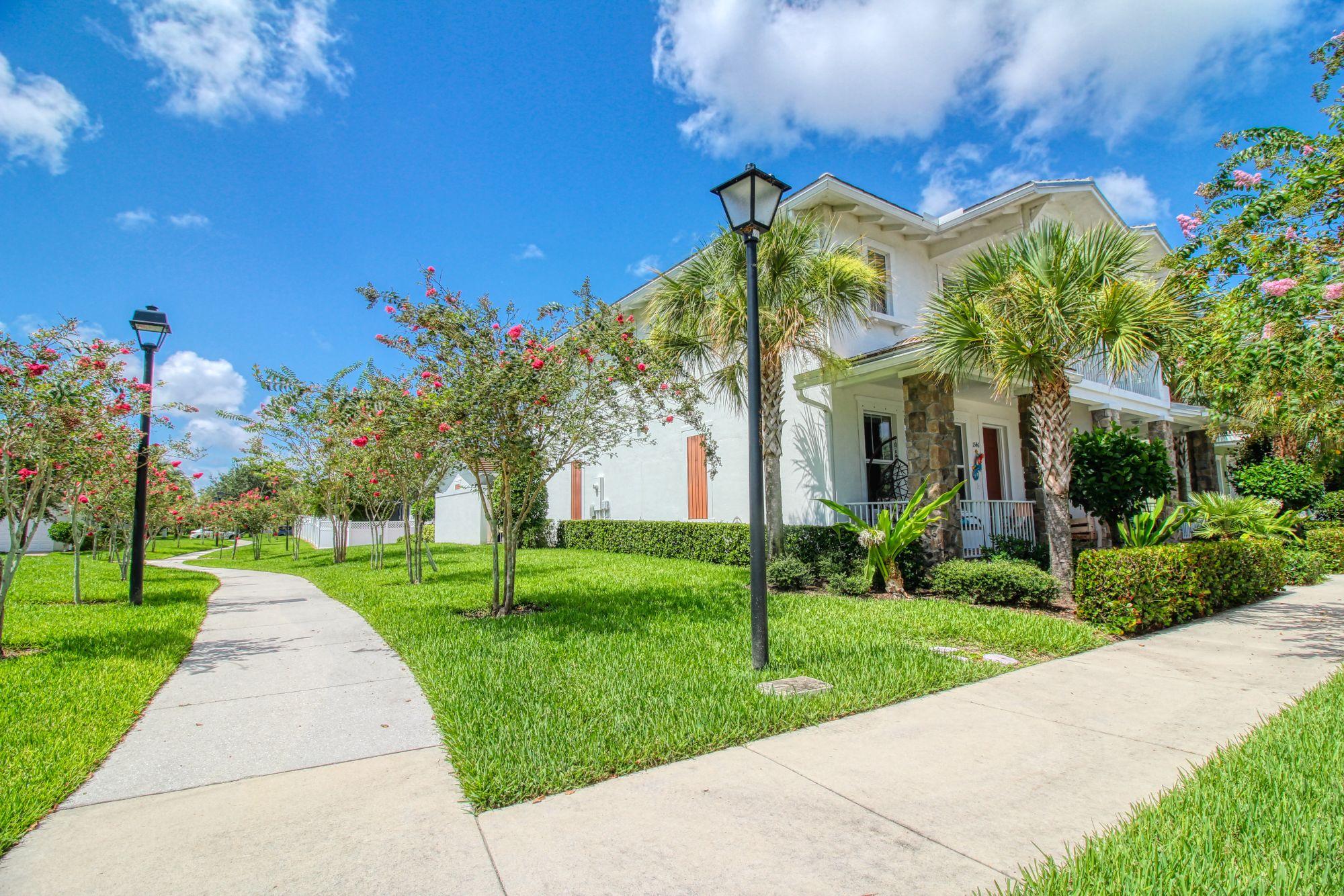 1346 Turnbridge Drive Jupiter, FL 33458 - Photo 2 of 46 a front view of a house with a yard and potted plants