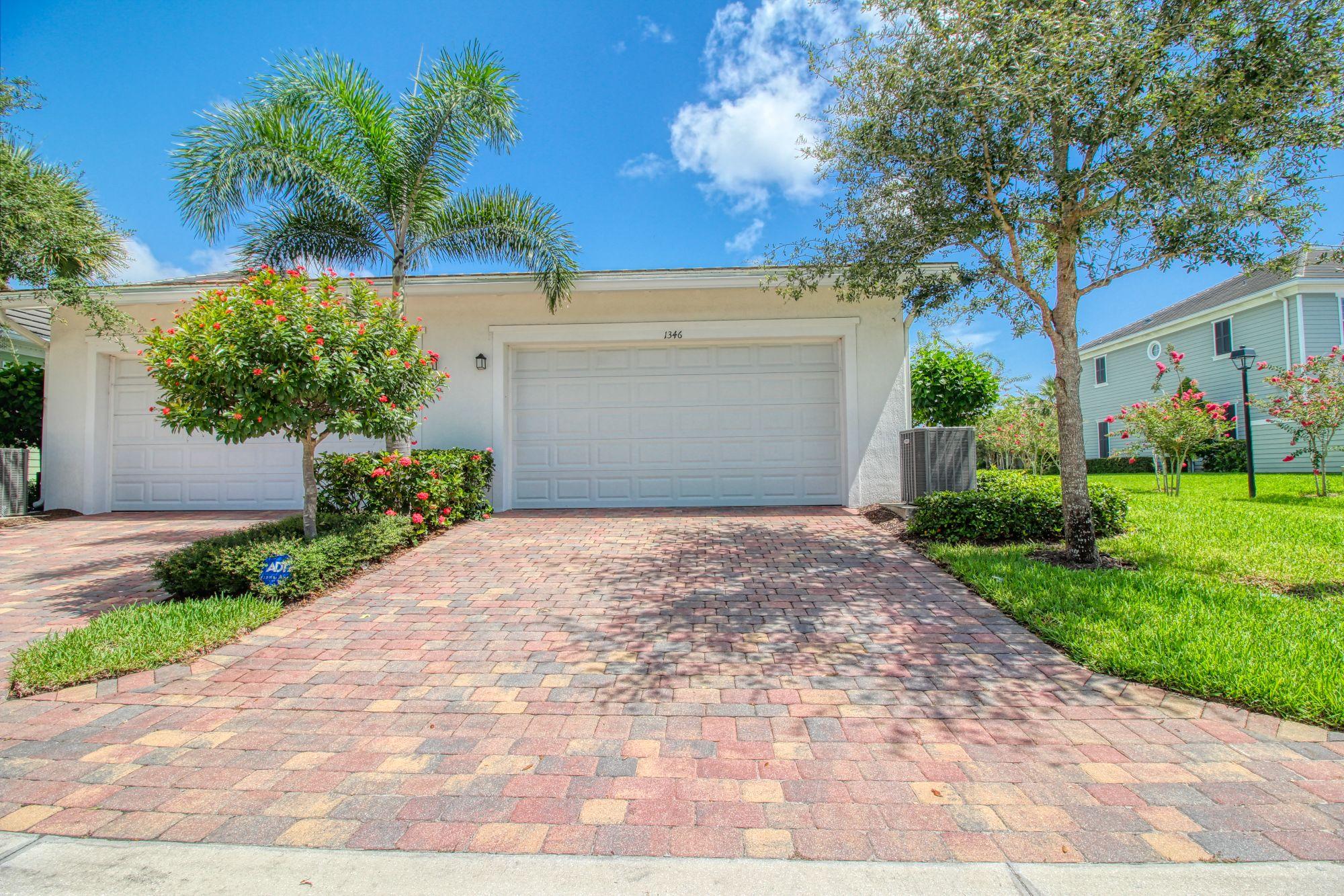 1346 Turnbridge Drive Jupiter, FL 33458 - Photo 4 of 46 a front view of a house with a yard and a garage