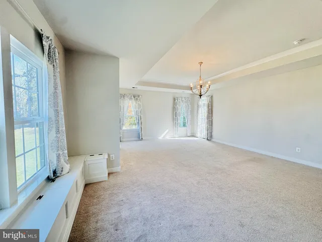 a view of a hallway with a livingroom and natural light