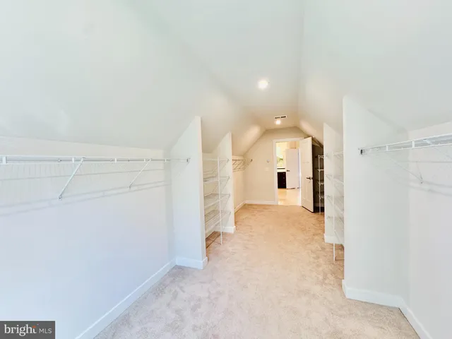 an empty room with closet and a chandelier fan