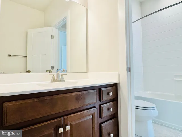 a view of an empty room with wooden floor and windows