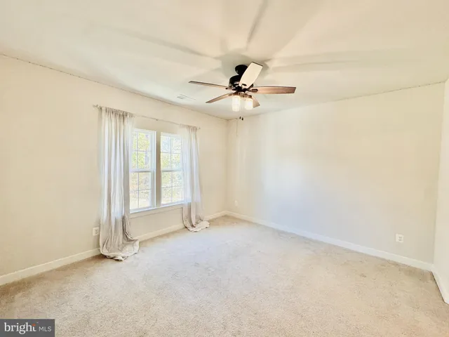 a view of a livingroom with furniture an oven wooden floor and windows