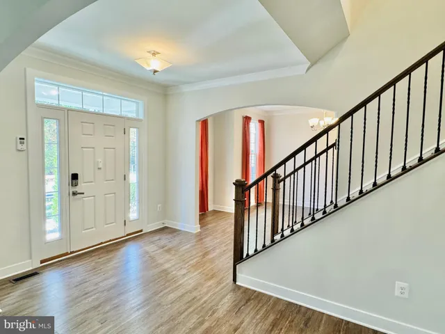 a large kitchen with stainless steel appliances kitchen island a large counter top and a wooden floors