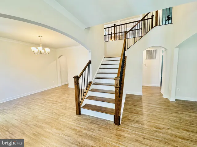 a view of staircase with wooden floor and a rug