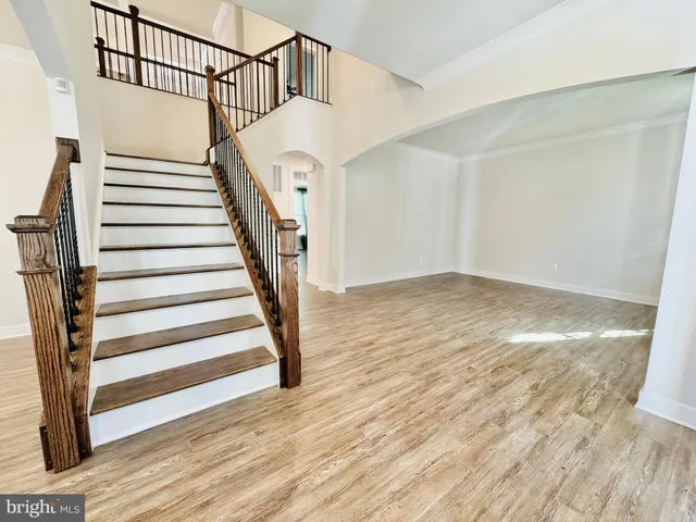 an empty room with windows and chandelier fan