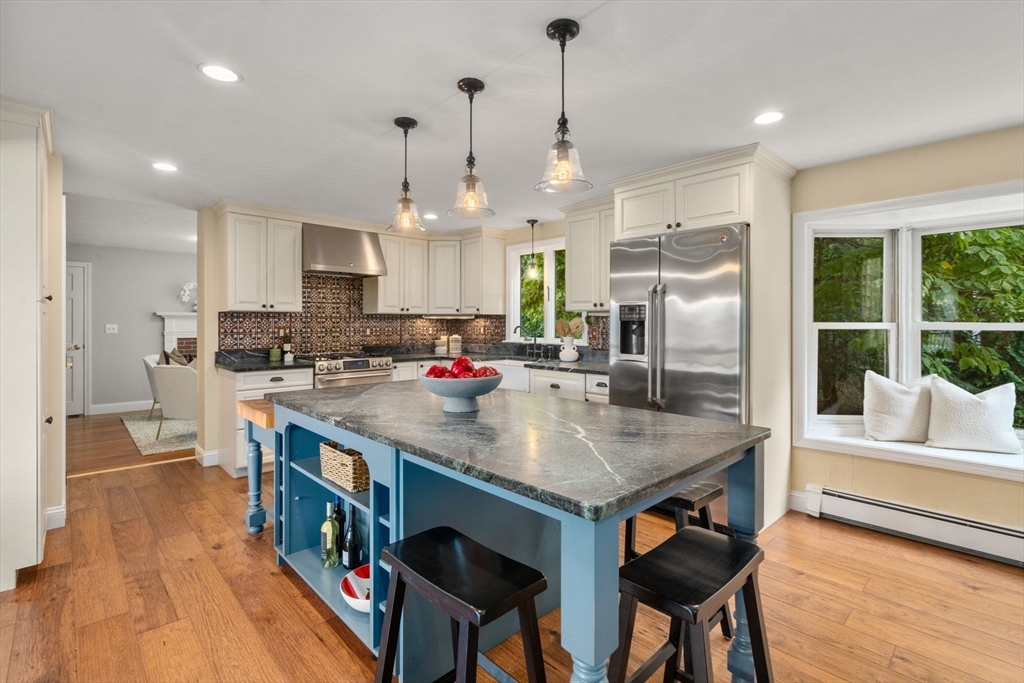 11 East Evergreen Road Natick, MA 01760 - Photo 2 of 30 a kitchen with stainless steel appliances granite countertop a kitchen island a stove a table and chairs