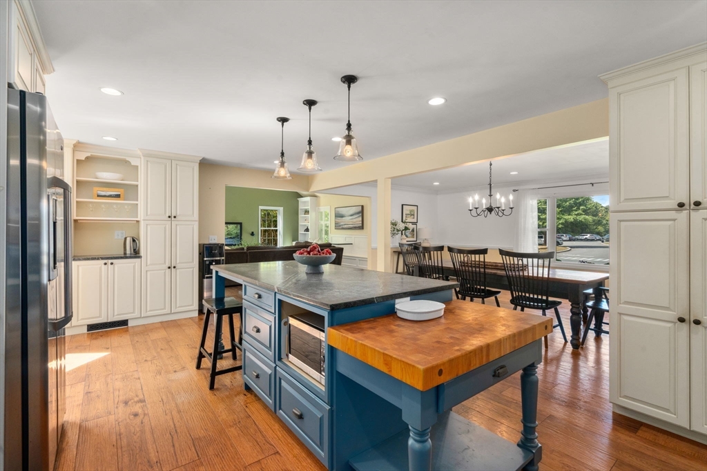 11 East Evergreen Road Natick, MA 01760 - Photo 3 of 30 a kitchen with a table chairs refrigerator and wooden floor
