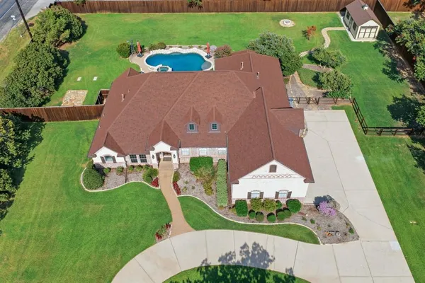 an aerial view of a house with a garden and trees