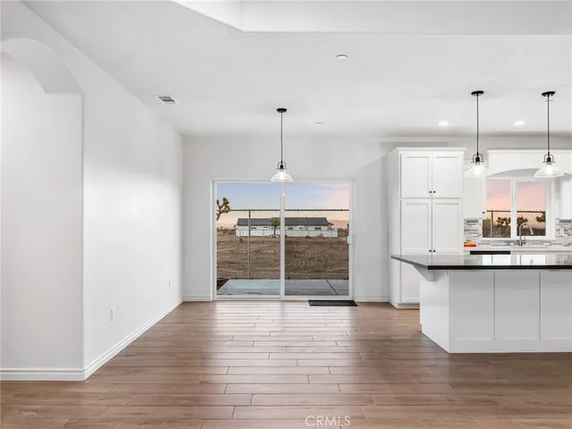 a view of a kitchen with wooden floor and a window