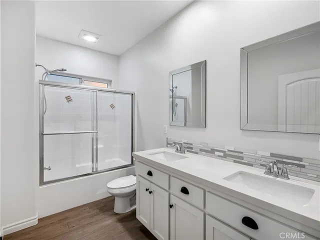 a bathroom with a granite countertop sink toilet a mirror and shower