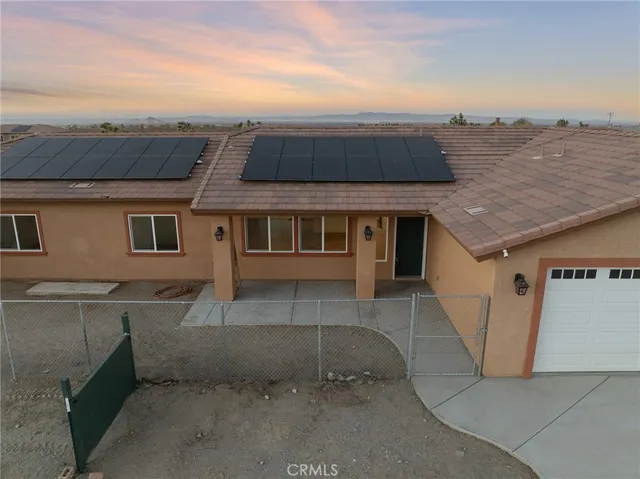 an aerial view of a house with a yard and mountain view