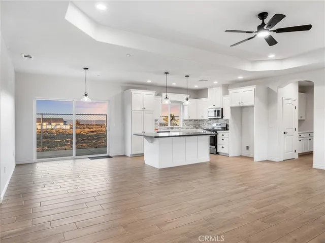 a view of kitchen with refrigerator stove and wooden floor