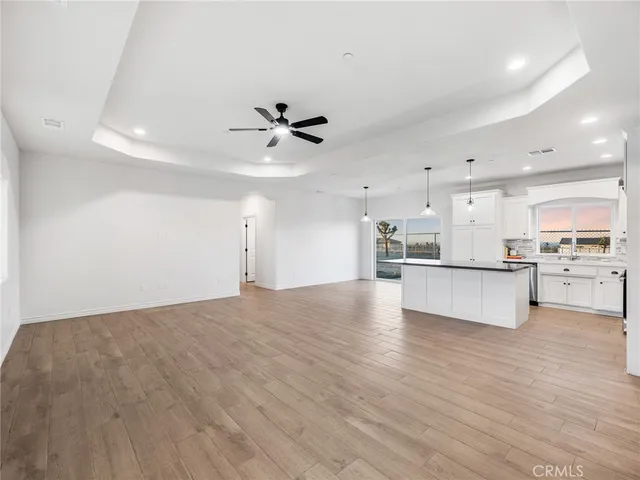a view of a kitchen with kitchen island a sink stainless steel appliances and cabinets