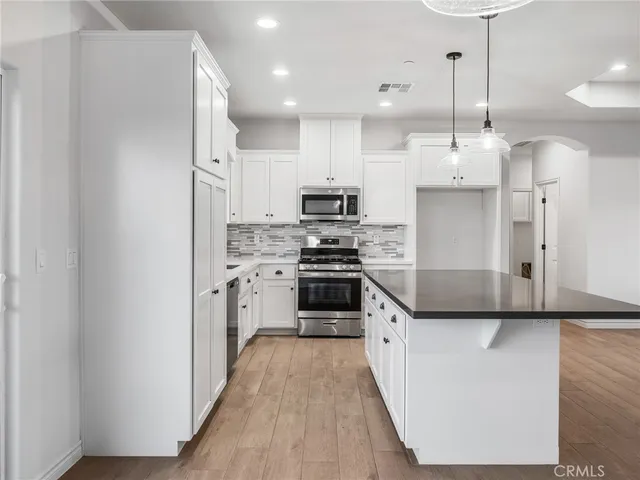 a kitchen with stainless steel appliances a refrigerator a stove a sink and a center island