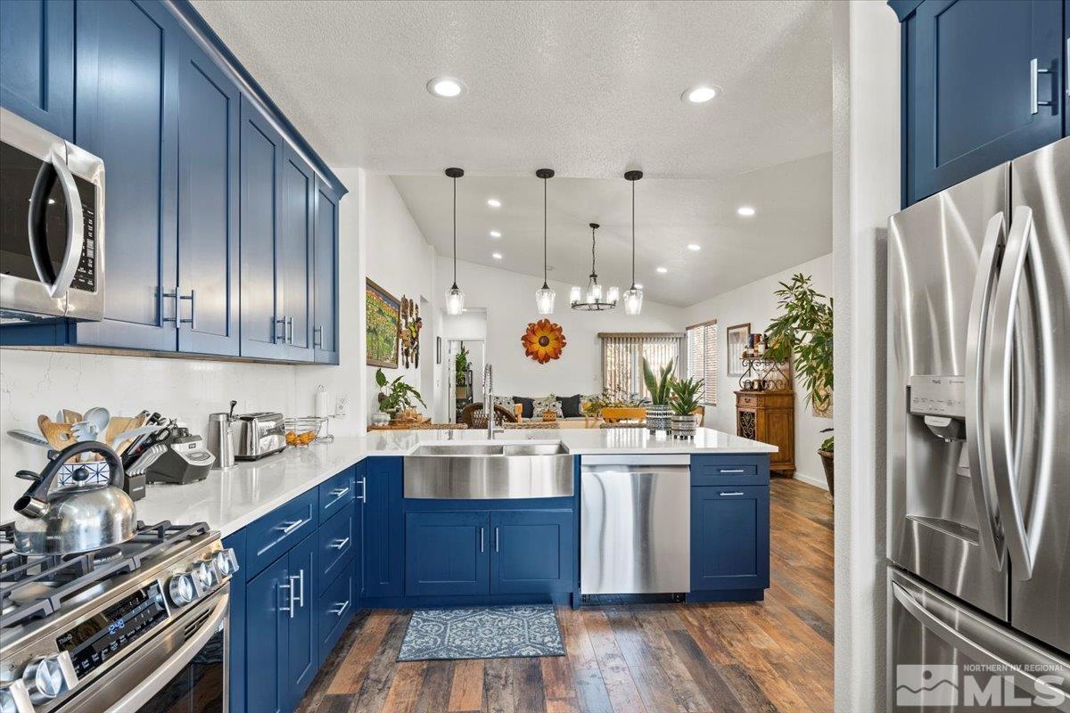 2151 Brittany Meadows Drive Reno, NV 89521 - Photo 2 of 40 a kitchen with stainless steel appliances granite countertop a refrigerator a sink dishwasher a stove and white countertops with wooden floor