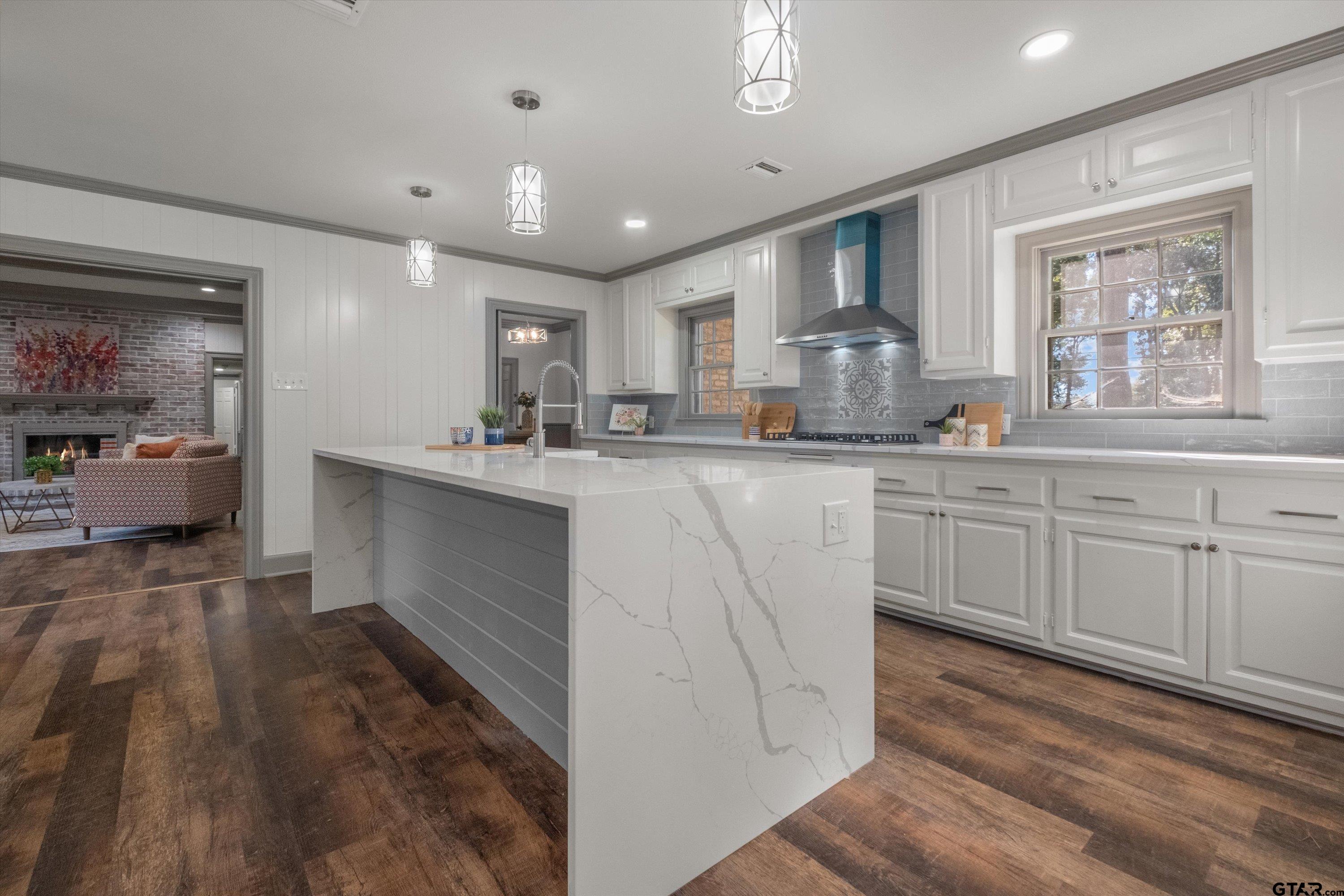 a kitchen with white cabinets and sink