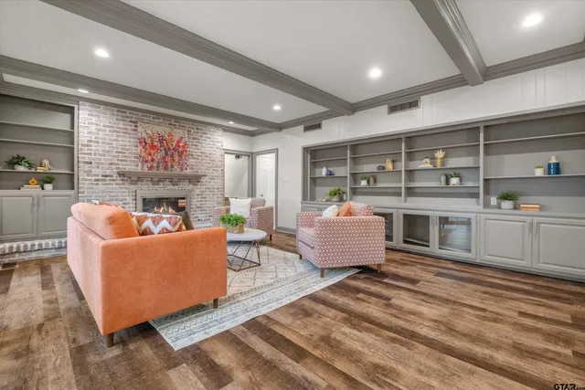 a living room with furniture a rug kitchen view and a large window