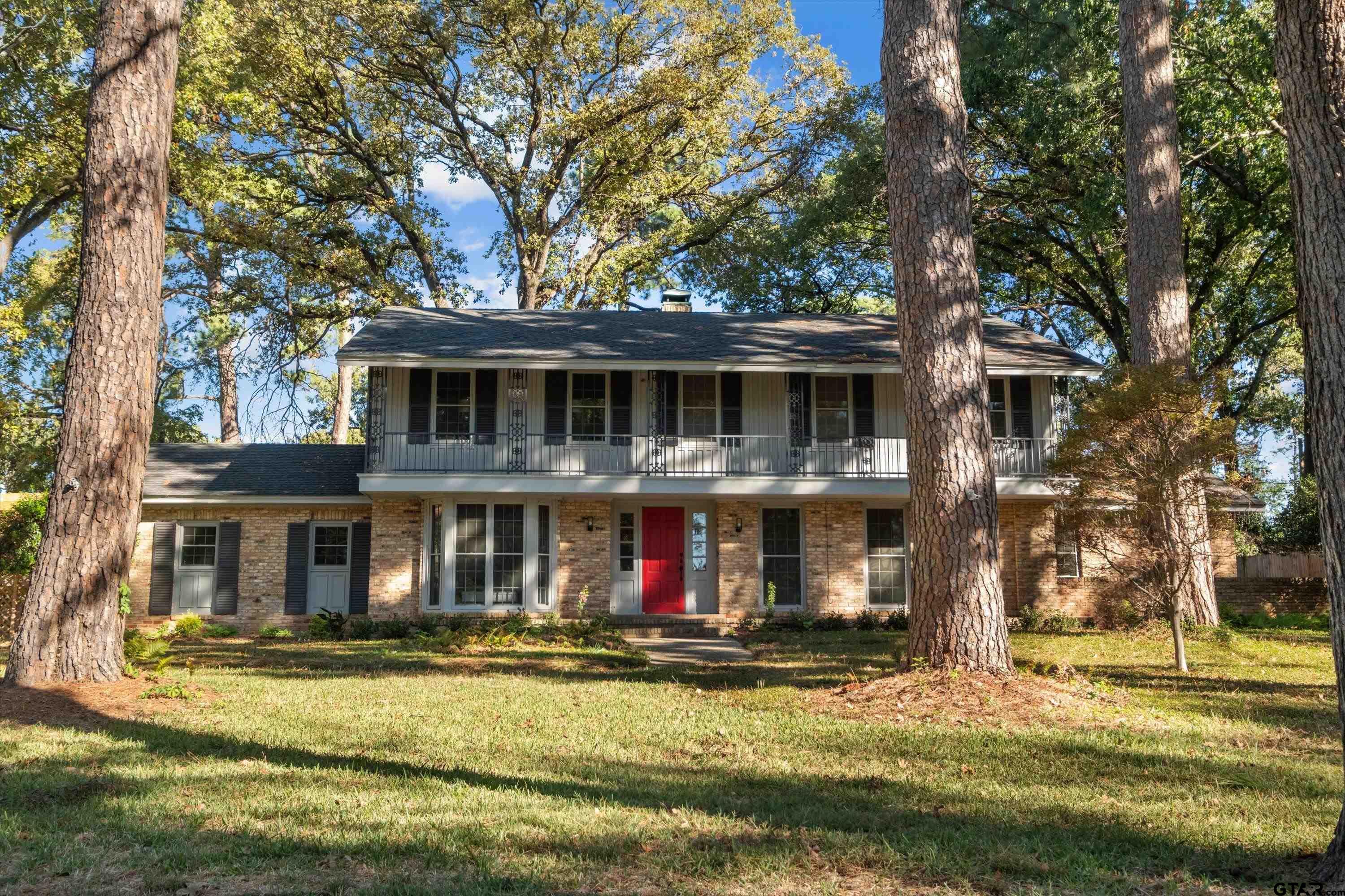 2126 McDonald Road Tyler, TX 75701 - Photo 3 of 26 a view of a brick house with large windows and a big yard