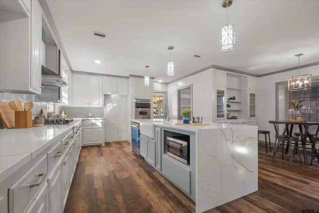 a kitchen with white cabinets and stainless steel appliances
