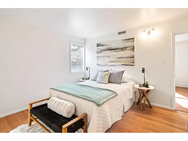 a bedroom with a bed and wooden floor