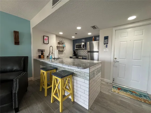 a kitchen with kitchen island stainless steel appliances a sink and cabinets