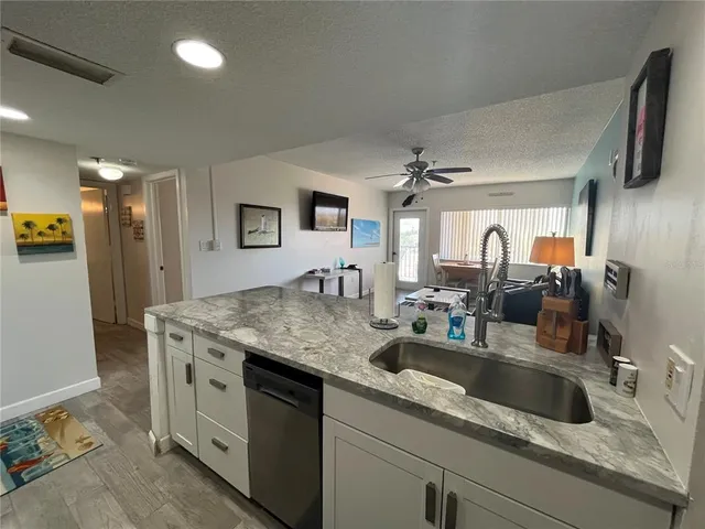 a kitchen with stainless steel appliances granite countertop a sink and a refrigerator